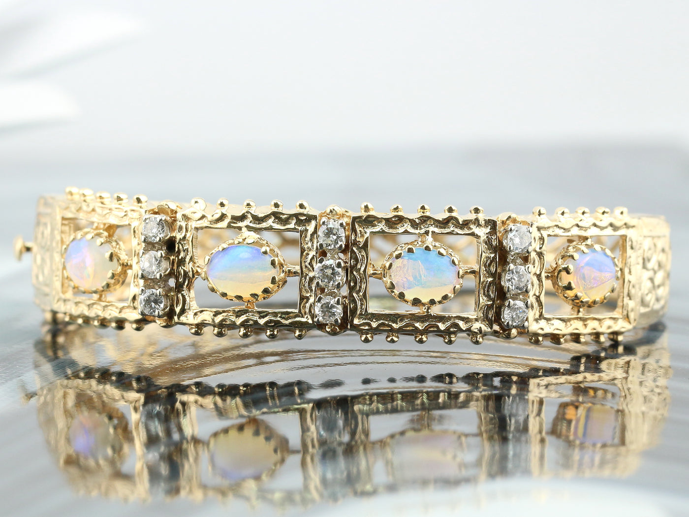 Yellow gold bangle with diamonds and opals